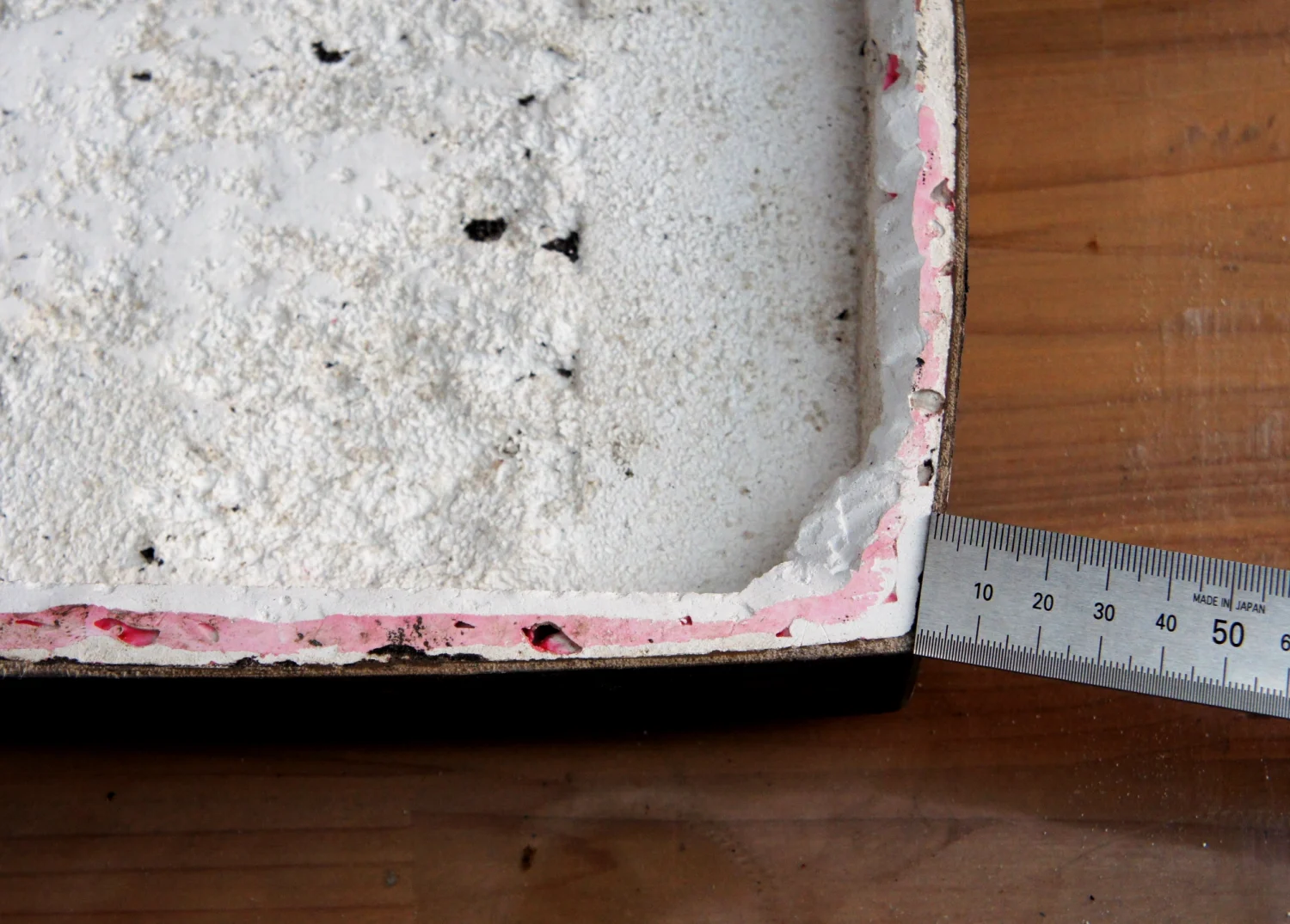 石膏を外す準備として、80番の耐水ペーパーを平らな台に敷き、その上で全体をこするようにして、縁の平らな面（水平）を出していきます。小口の厚みは2.2mmでした。