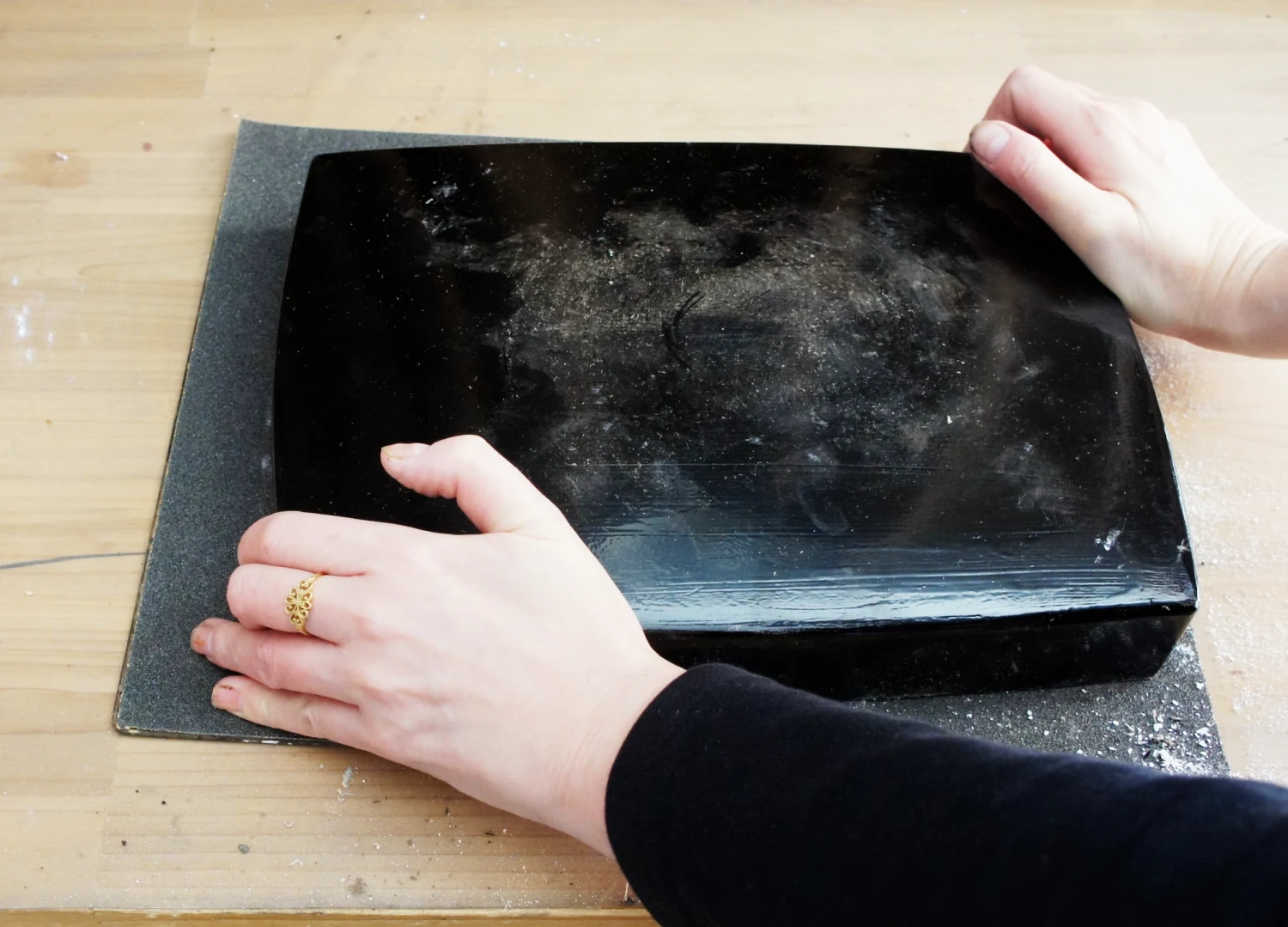 石膏を外す準備として、80番の耐水ペーパーを平らな台に敷き、その上で全体をこするようにして、縁の平らな面（水平）を出していきます。